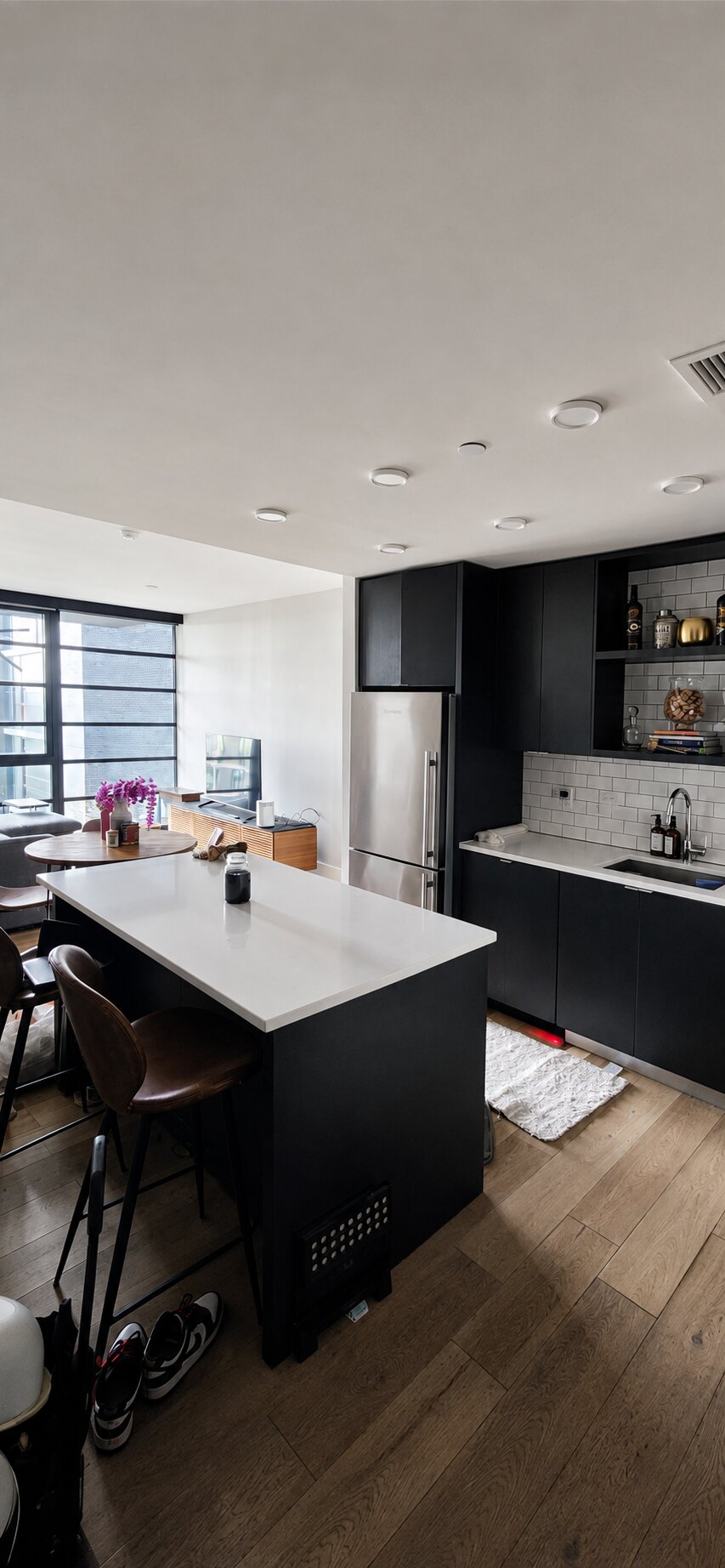 Refined modern open-plan kitchen with dark cabinetry and a white island