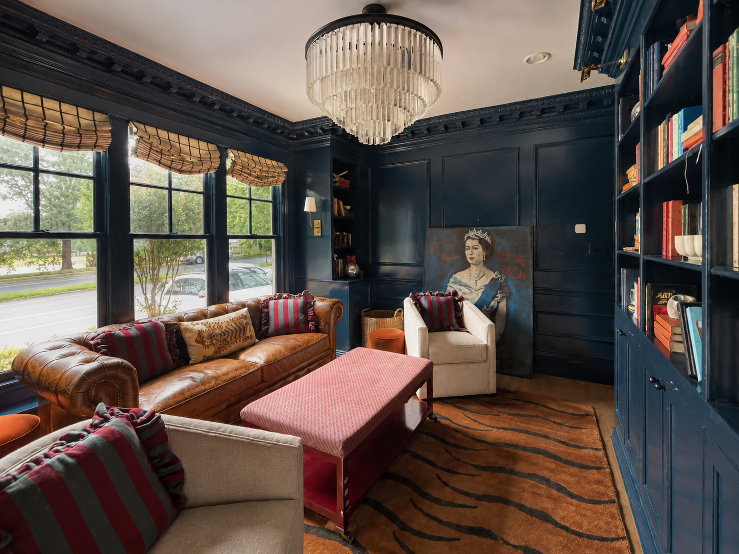 Organized living room with deep-blue walls, a crystal chandelier and leather seating